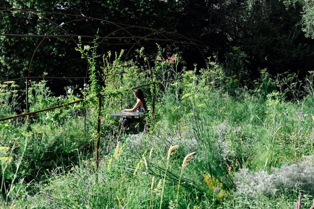 a woman sitting on a bench in a field at Hôtel du Couvent, a Luxury Collection Hotel, Nice in Nice