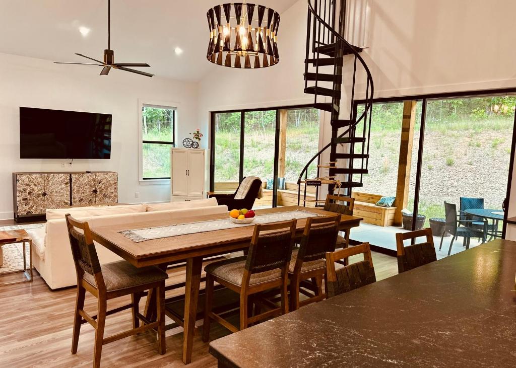 een woonkamer met een tafel en stoelen en een trap bij Deluxe Fun House - Pet Friendly in Piney
