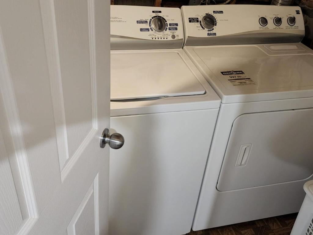 a white washer and dryer sitting next to a door at Your home away from home in Pickering
