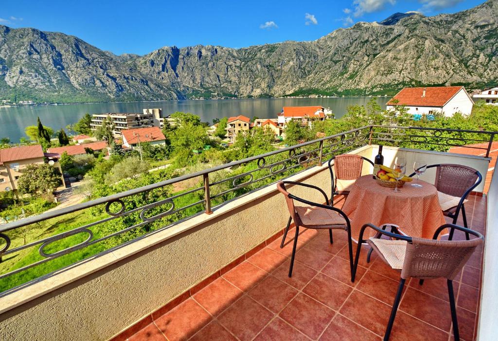 a balcony with a table and chairs and a view of a lake at Apartments Soso in Kotor