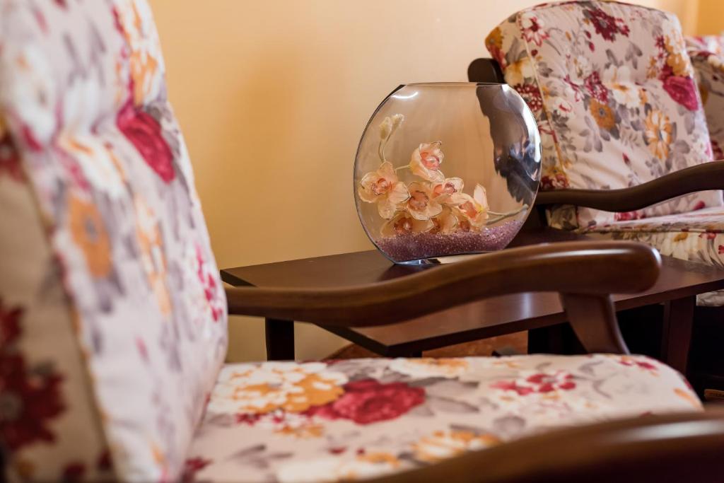eine Vase auf einem Tisch neben einem Stuhl in der Unterkunft Monte Carlo Reghin in Reghin