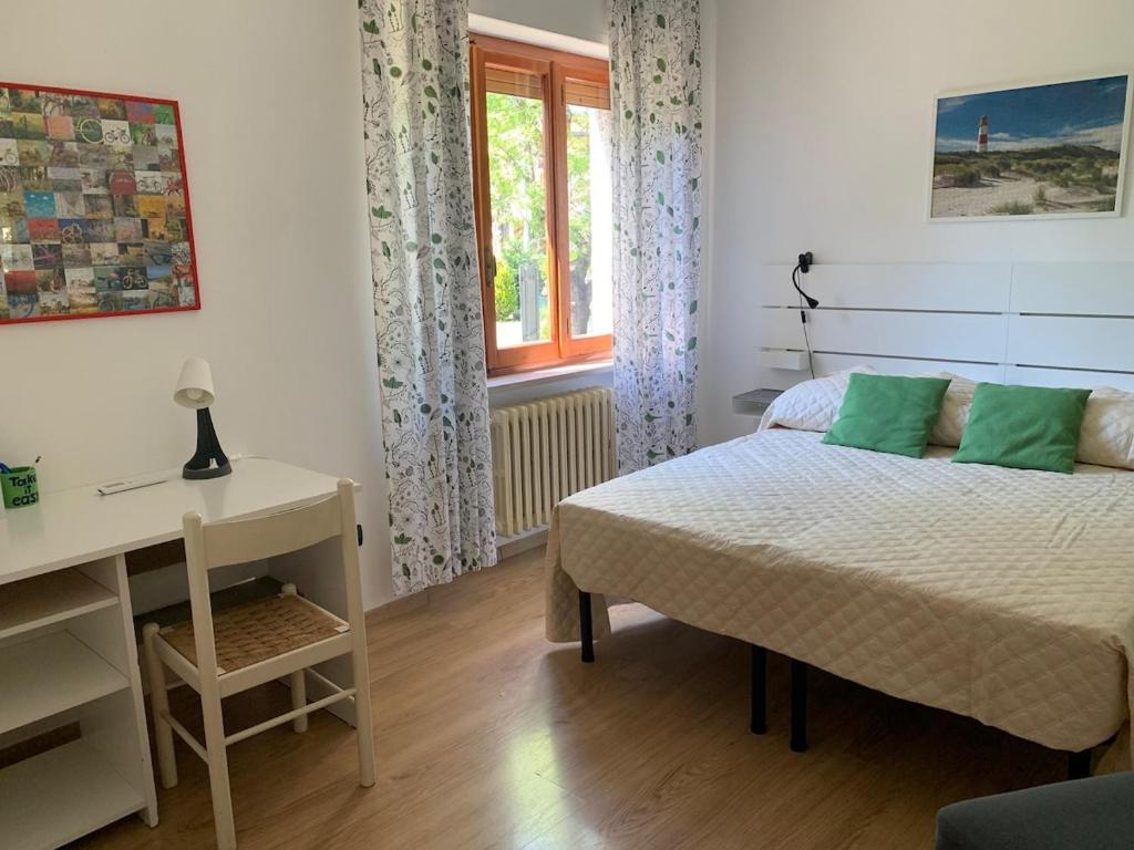 a bedroom with a bed and a desk and a window at Casa vacanze Margherita in Fossacesia
