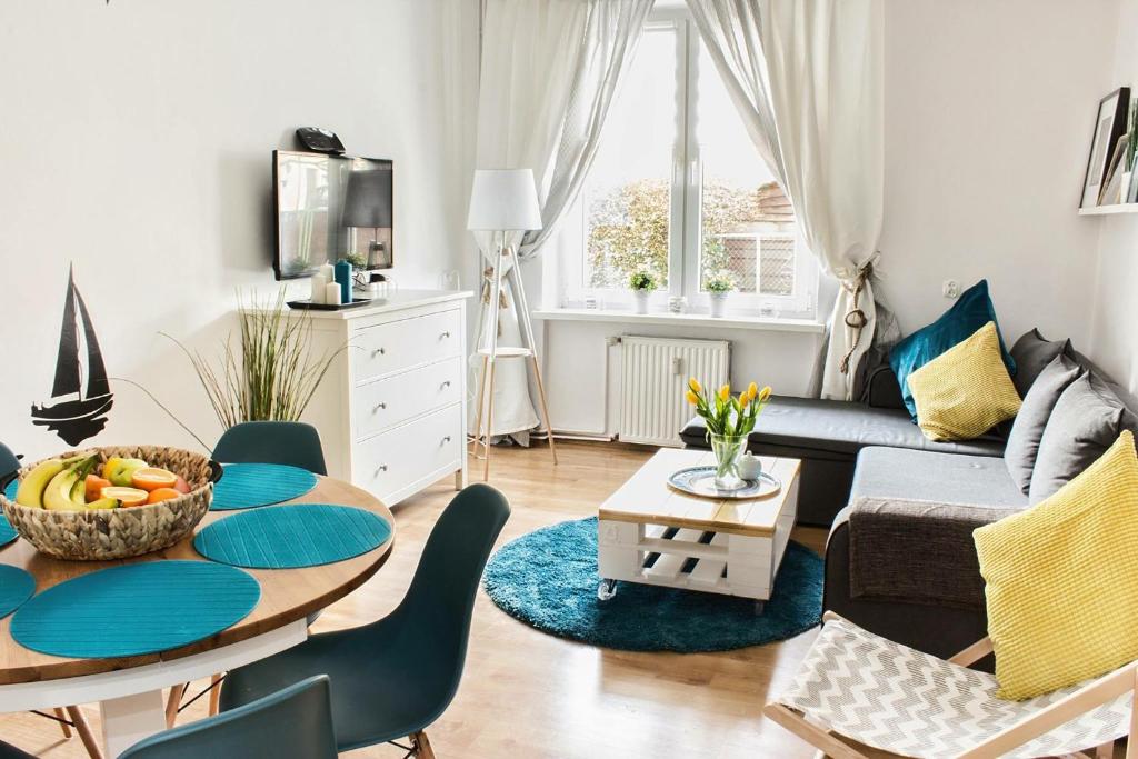 a living room with a table and a couch at Apartament Kapitański Władysławowo in Władysławowo