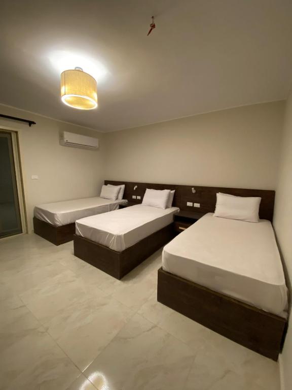 a room with two beds and a light at Rivera Apartment in Cairo
