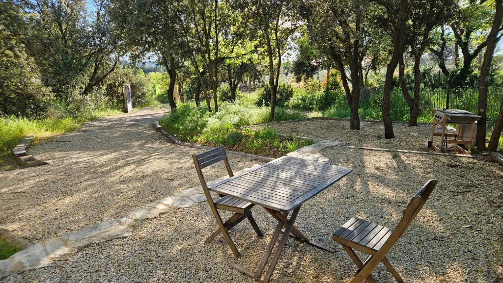 une table en bois et deux chaises assises à côté d'une route dans l'établissement Au cœur du Luberon, à Cadenet