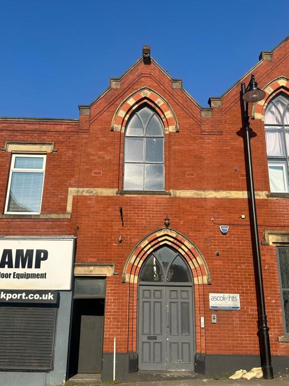 ストックポートにあるHillgate Loftのドアと街灯のある赤レンガの建物