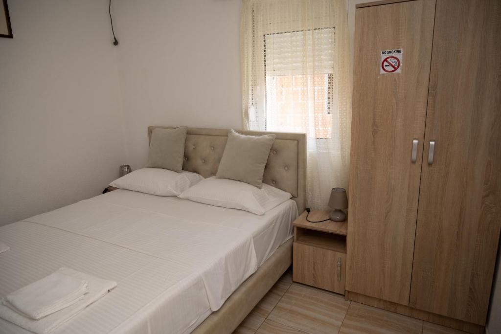 东吉托伊apartmani DENI的一间带床和木柜的小卧室