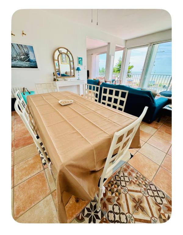 - une table à manger avec des chaises et un canapé dans l'établissement Vacances en Famille face mer - plage à Pontaillac, à Royan