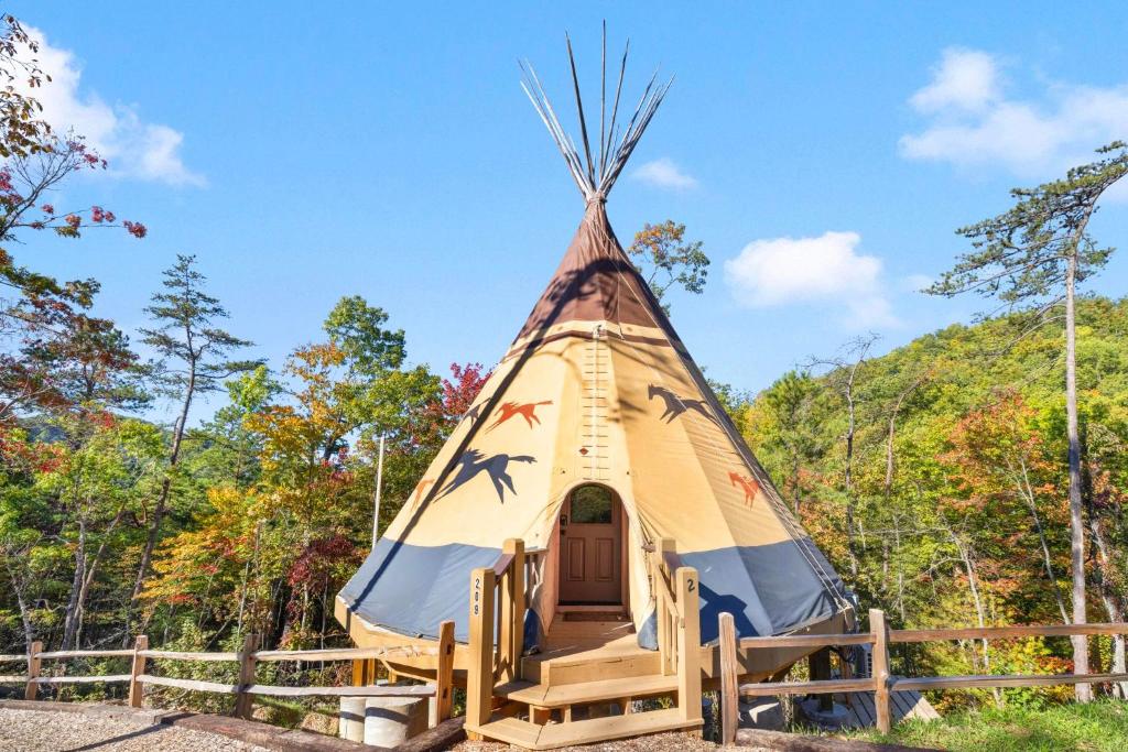 セバービルにあるFlyin' Horse Teepee, Free Tickets, NO catch!の森の中にある柵付きのパオ