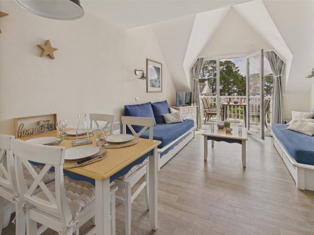 un salon avec une table et un canapé dans l'établissement Balcon vue mer et piscine pour 4 personnes, à Fouesnant
