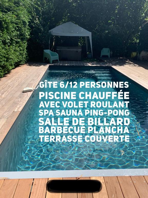 une piscine avec un gazebo et un panneau dans l'eau dans l'établissement Villa Marcel Spa Sauna Billard Piscine 25mn de Bordeaux, à Cérons