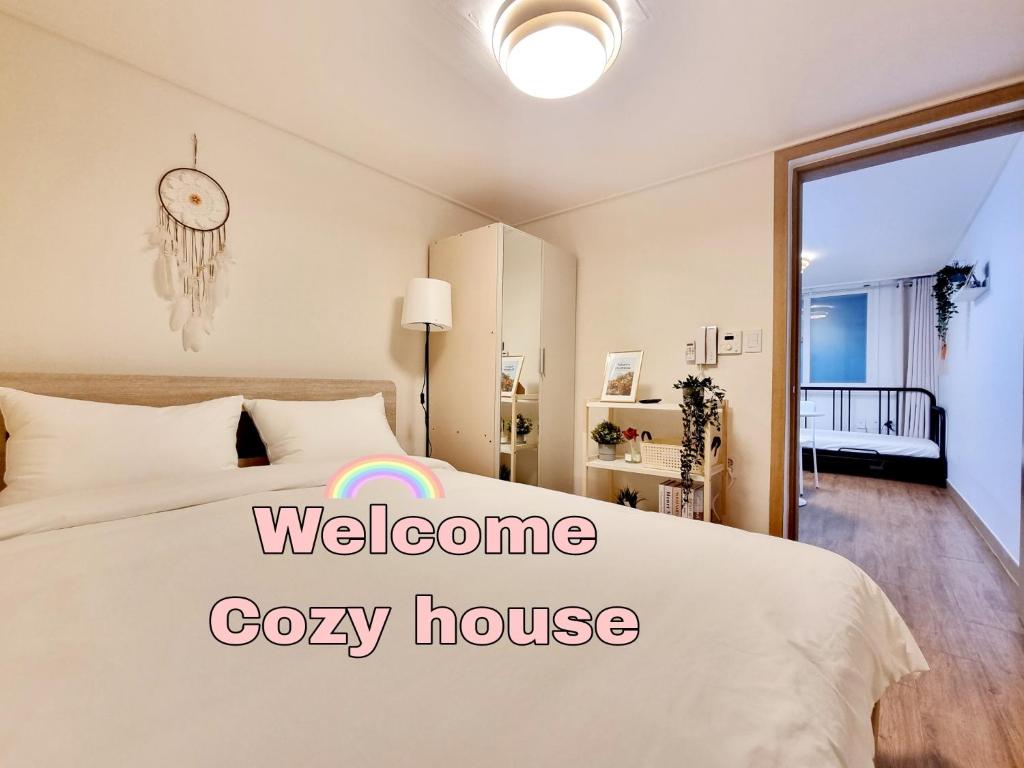 ein Schlafzimmer mit einem Bett mit einem Willkommensschild „Cozy House“ darauf in der Unterkunft Cozy house in Seoul