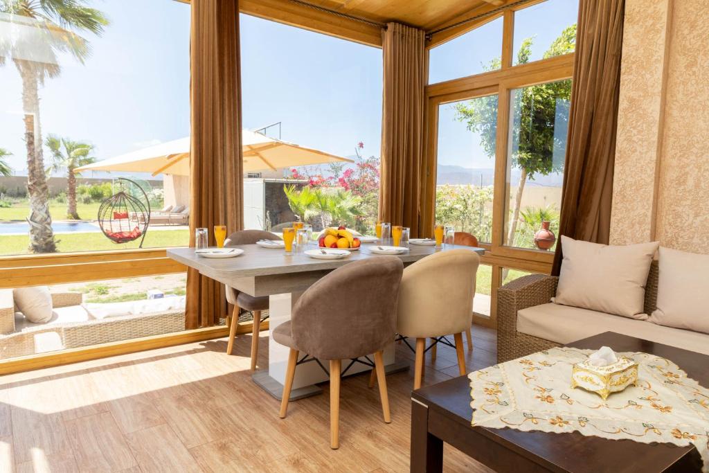 a dining room with a table and a large window at Peaceful Family Villa on a Farm with Private Pool and Stunning Mountain Views in Agadir