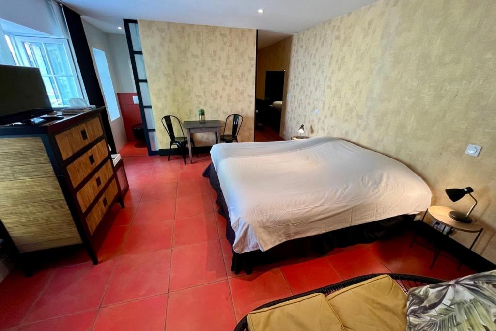 une chambre avec un lit et une table avec une chaise dans l'établissement Le Belem - Room in the heart of St Martin de Ré, à Saint-Martin-de-Ré