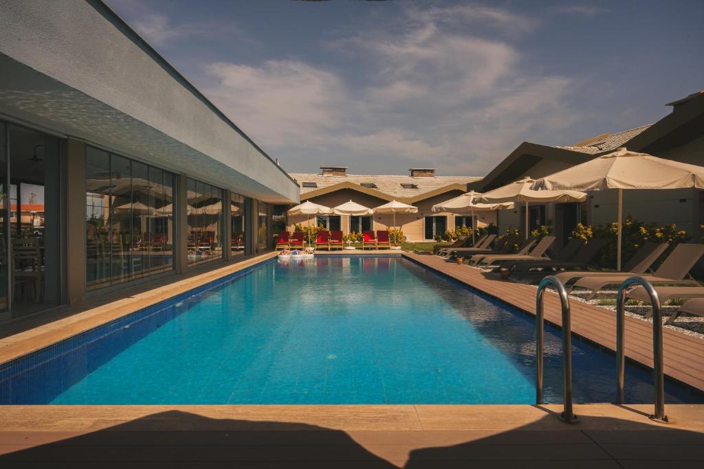 a pool at a hotel with chairs and umbrellas at La Vida otel in Urla