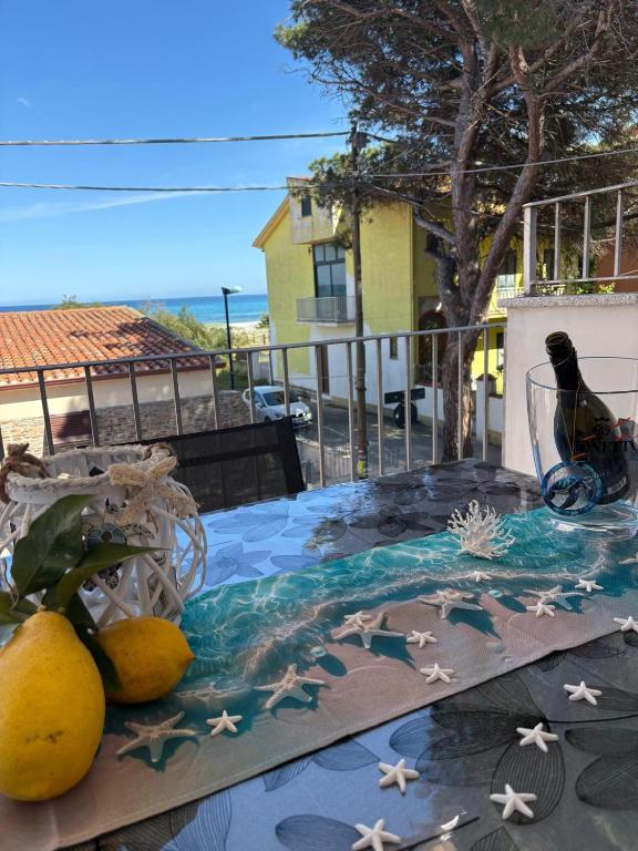 a table with lemons and a bottle of wine on it at all ombra dei pini in La Caletta