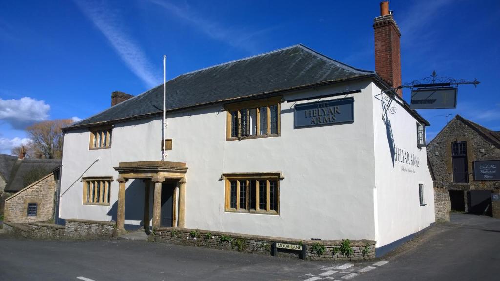 un bâtiment blanc avec un panneau indiquant les trusts de prestation dans l'établissement The Helyar Arms, à Yeovil