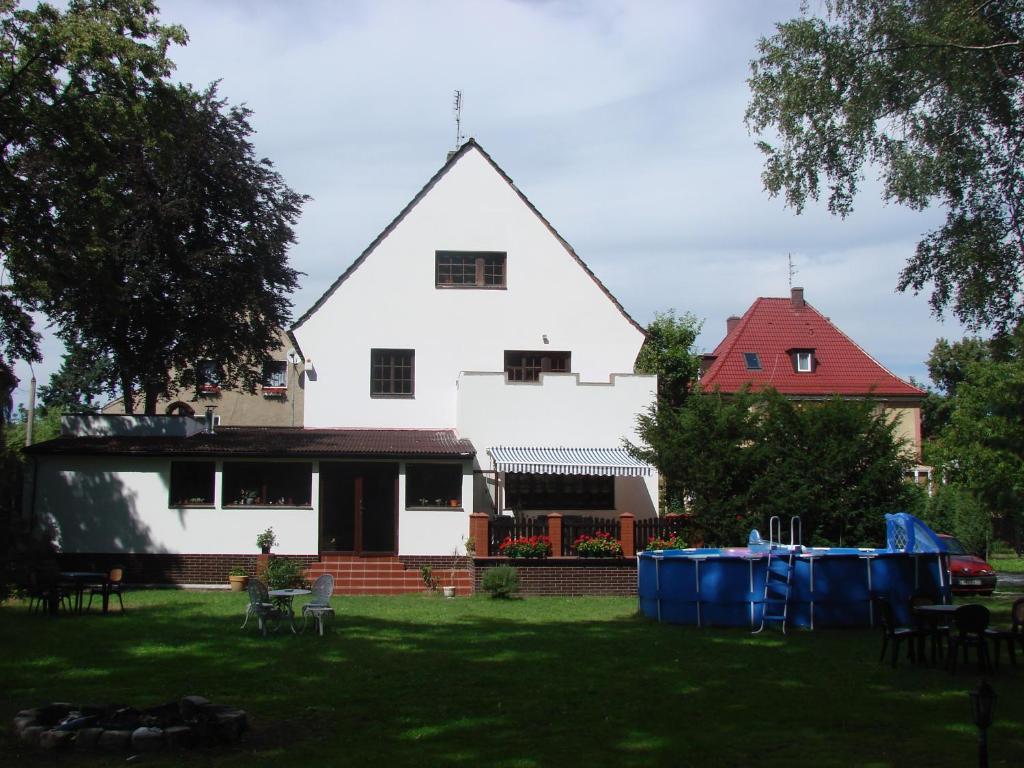 a house with a blue roof and a white house at Pensjonat Rezydencja Parkowa in Wrocław
