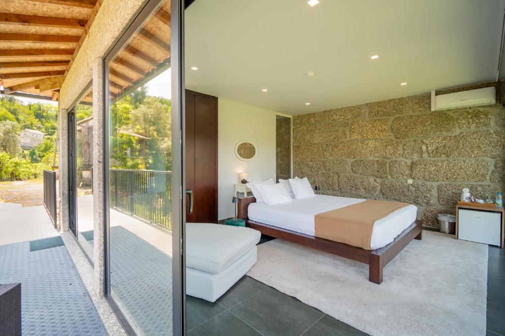 een slaapkamer met een bed en een balkon bij Quinta De Calvelos in Vieira do Minho