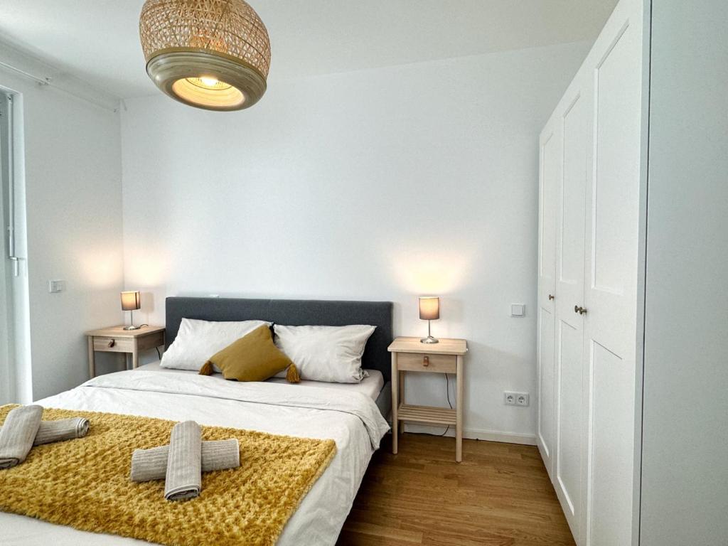 a bedroom with a bed and two side tables at HolidayHome Apartments I Airport Deluxe Condo with Terrace in Schönefeld