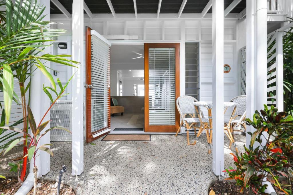 a front door of a house with a table and chairs at The Queenslander Family Townhouse Near Four Mile Beach in Port Douglas