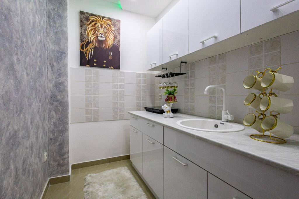 un bagno con un lavandino e un dipinto di un leone sul muro di Matija Lux2 a Kraljevo
