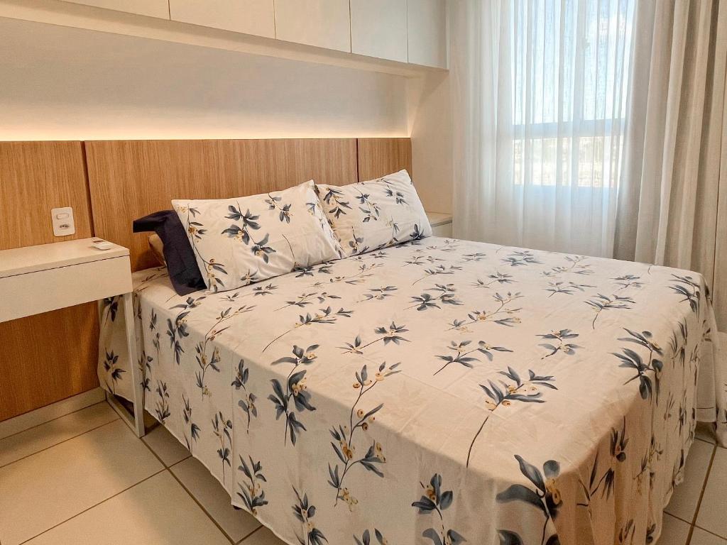 a bedroom with a bed with a blue and white comforter at 2Qts, 6km do Parque do Povo in Campina Grande