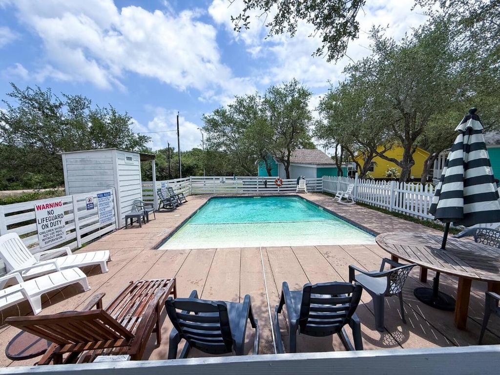 una piscina con sedie, tavolo e ombrellone di Going Coconuts By The Pool a Rockport