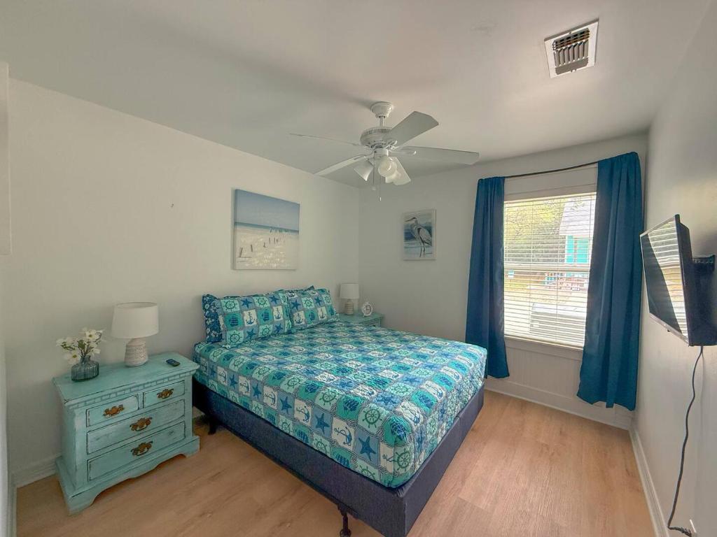 una camera da letto con un letto e un ventilatore a soffitto di Going Coconuts By The Pool a Rockport