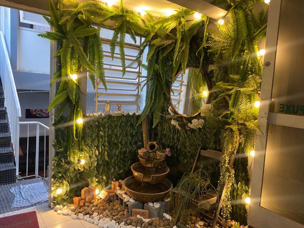 a room with a fountain and plants and lights at Hostel JF in Sao Paulo