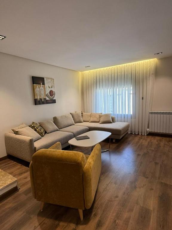a living room with a couch and a table at Duplex trouville à 2 pas de la plage in Aïn El Turk