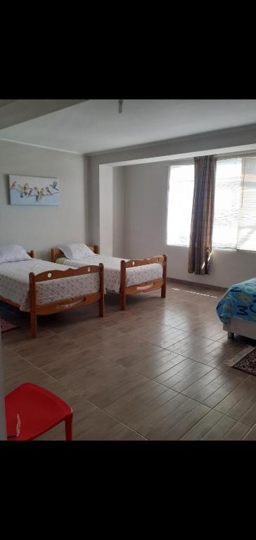 a bedroom with two beds and a large window at Noah'house in Nazca
