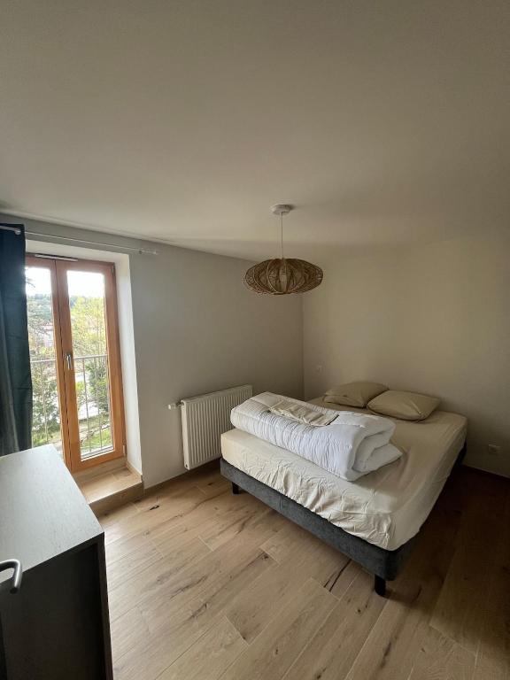 une chambre avec un lit et une grande fenêtre dans l'établissement Apparemment neuf centre ville, à Brives-Charensac