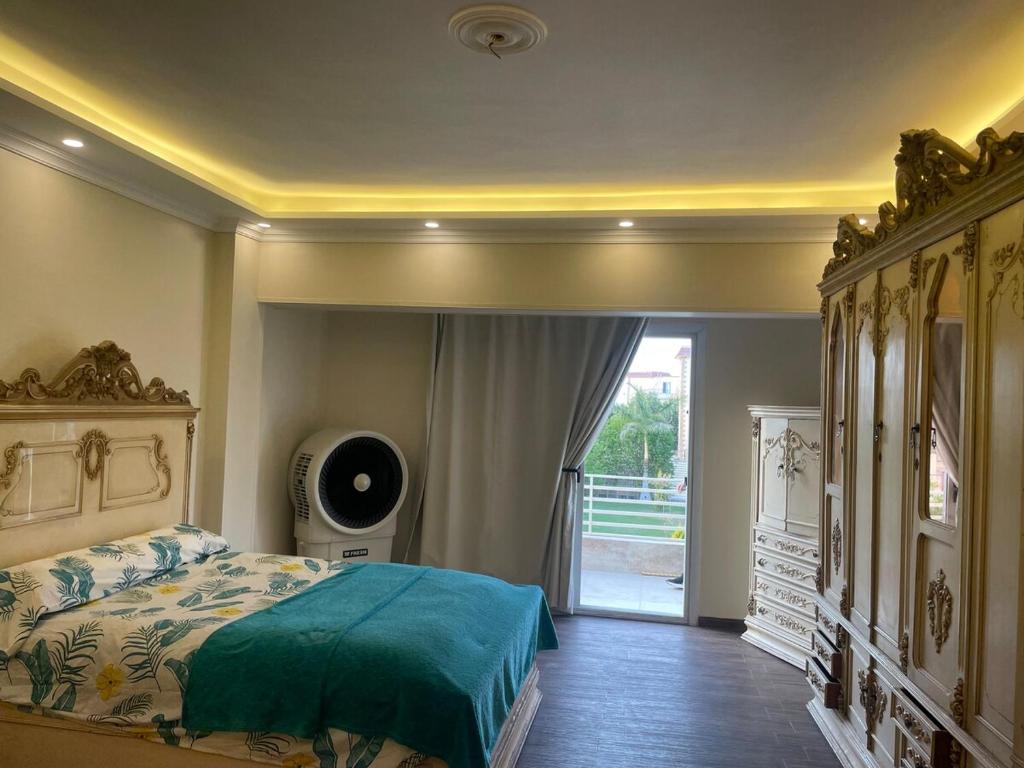 a bedroom with a bed and a door to a yard at Villa Ayoun El Nakheel Luxury Family Stay with Garden and Pool in Sphinx International Airport