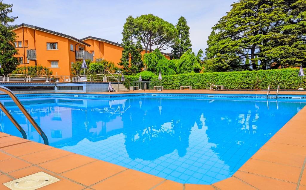 a large swimming pool with blue tile in a yard at Appartamento Peschiera in Peschiera del Garda