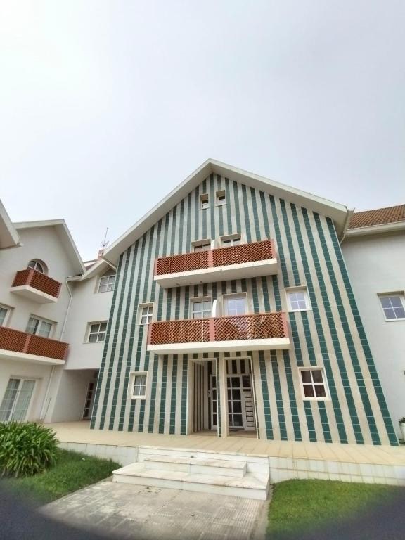 a building with a green and white at Boa Vista Apartamento in Gafanha da Encarnação