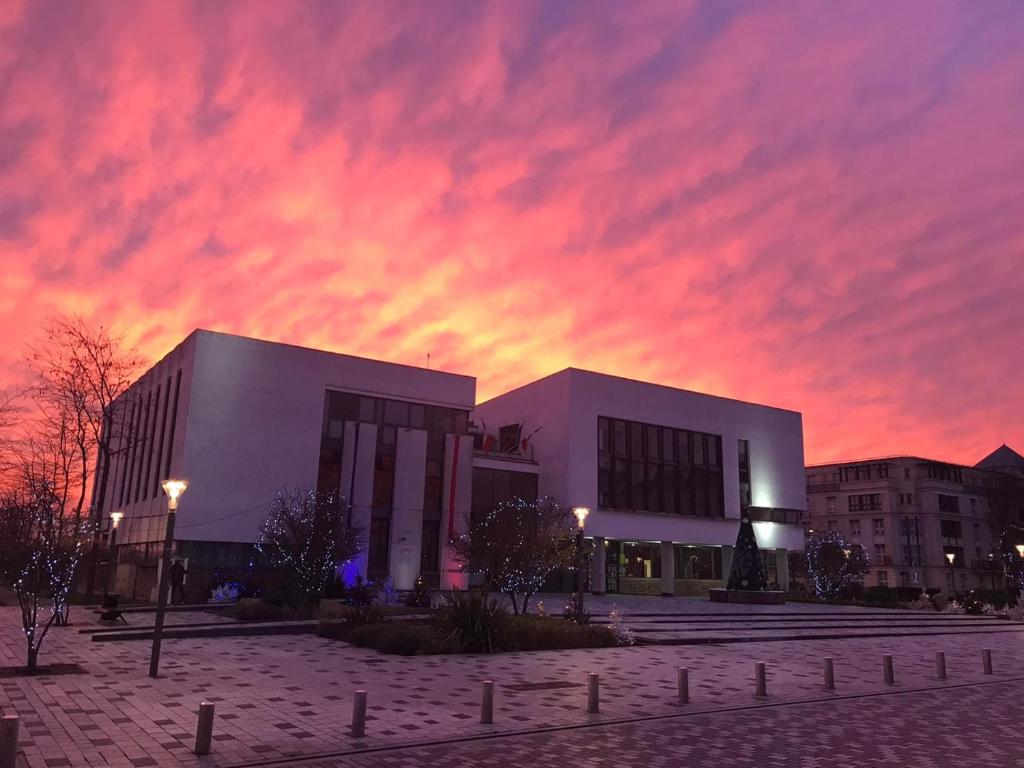 un bâtiment avec un ciel nuageux au coucher du soleil dans l'établissement Disneyland smart appartement, à Serris