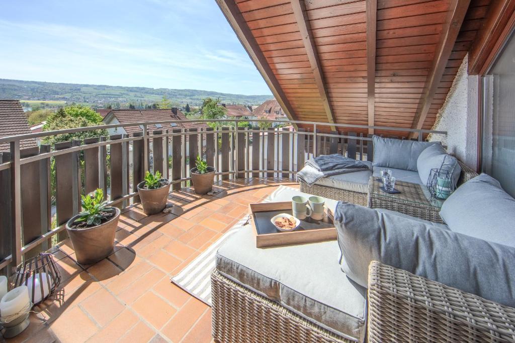 a patio with a couch and chairs on a balcony at Fewo Seetraum in Öhningen