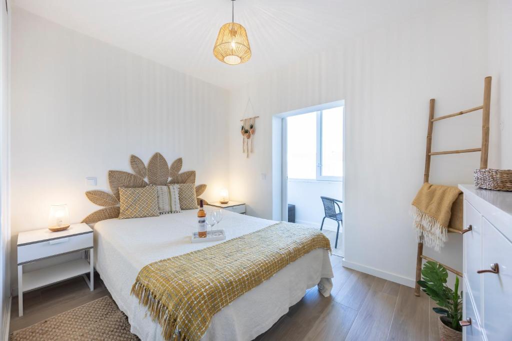 una camera da letto bianca con un letto e una finestra di Casa da Vila a Vila do Bispo