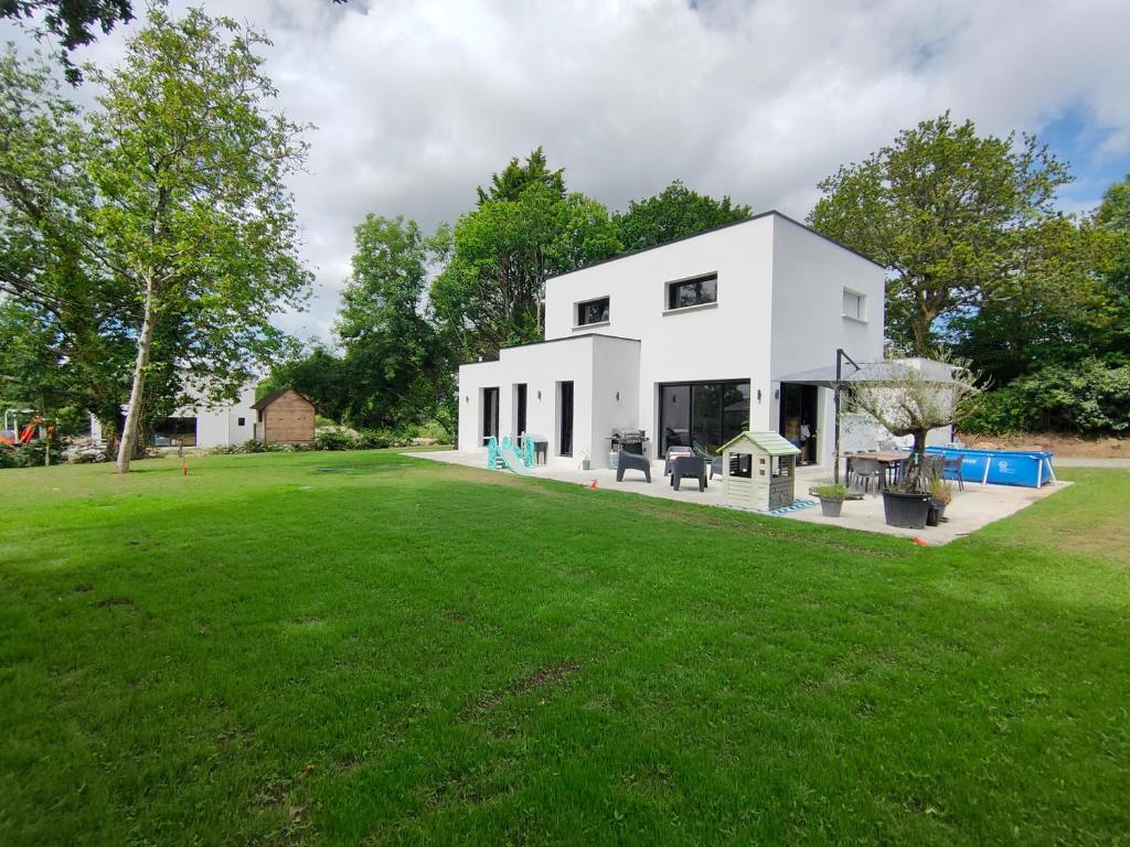 une maison blanche avec une grande cour verdoyante dans l'établissement La casa Gina, à Gouesnach