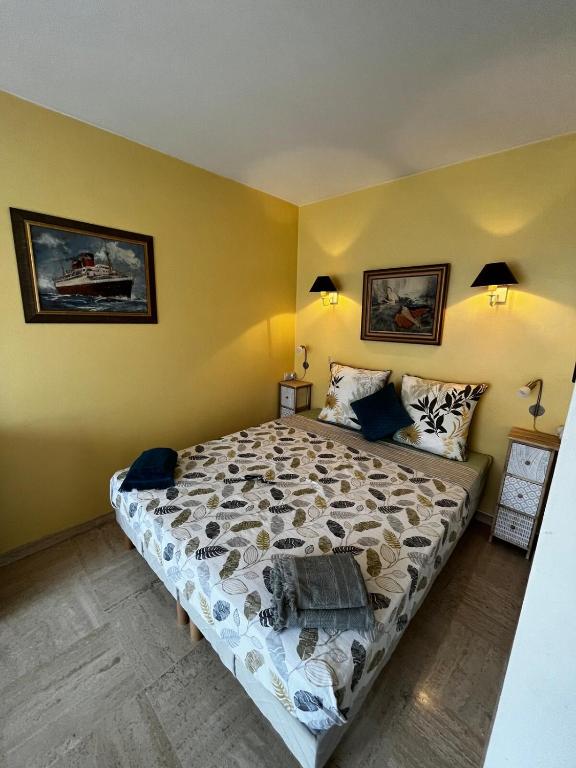 une chambre avec un lit et deux tableaux au mur dans l'établissement Studio lumineux Croisette, à Cannes