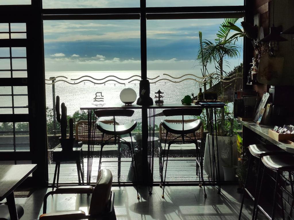 a room with a table and a view of the ocean at 濱境行旅 Begin Inn in Xiaoliuqiu