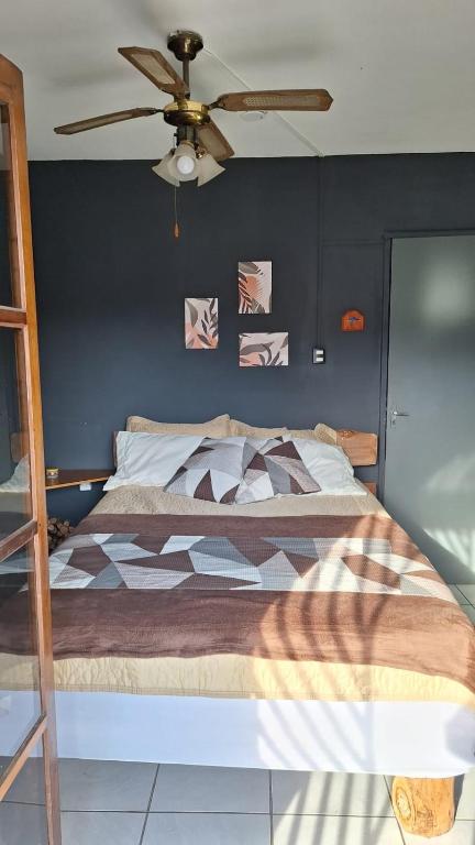 a bedroom with a bed with a ceiling fan at RustiCidade in São Paulo