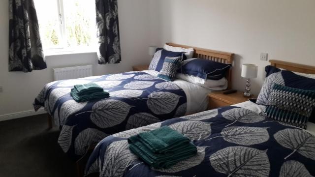 1 dormitorio con 2 camas en azul y blanco en Castaway Guesthouse, en Kirkwall