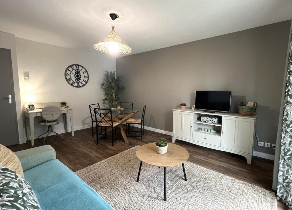 a living room with a blue couch and a table at Appartement Nature au calme in Albi