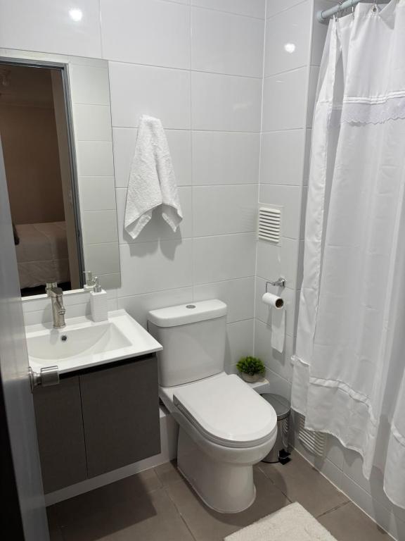 a white bathroom with a toilet and a sink at Dormitorio individual - Baño, Altos de San Miguel in Talca