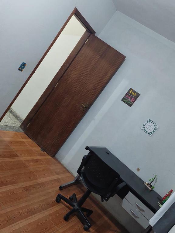 a room with a desk and a door and a chair at Sítio Rodrigues in Pedro Leopoldo