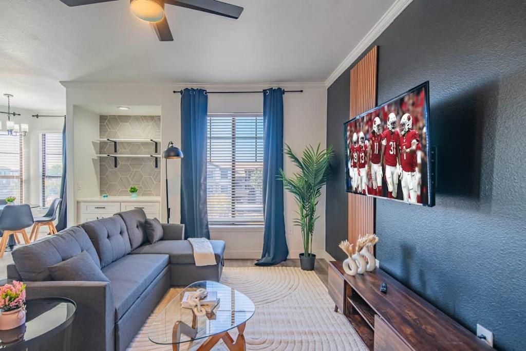 a living room with a couch and a tv at Amiable 2BD King Bed with Pool, Hot Tub, Gym, Parking in Glendale