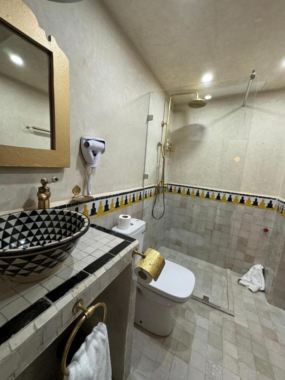 a bathroom with a shower and a toilet and a sink at Riad M'Barka in Tangier