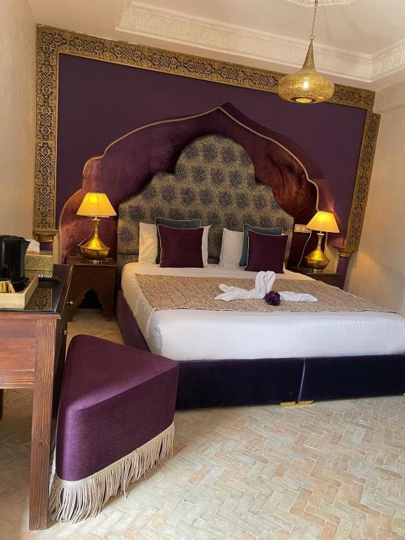 a bedroom with a large bed with a purple wall at Riad M'Barka in Tangier